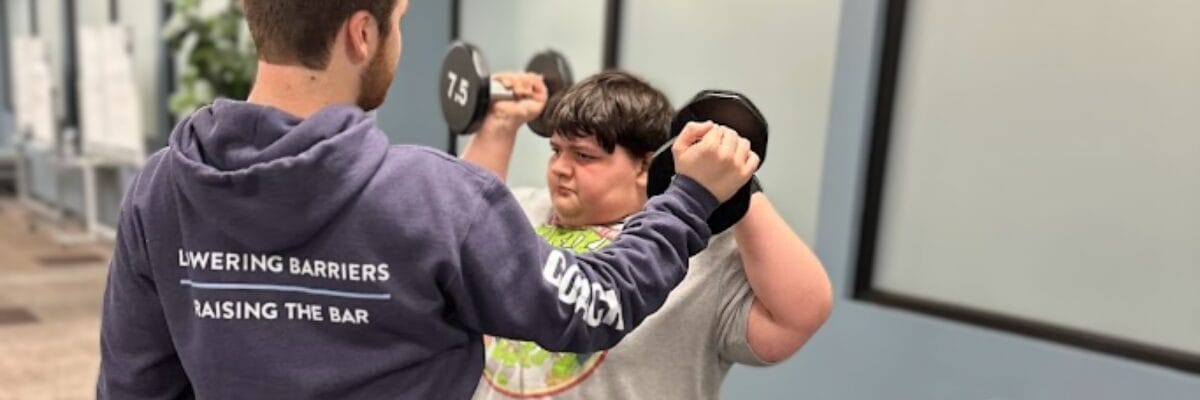 Inclusive Fitness Coach helping with Dumbbells Training